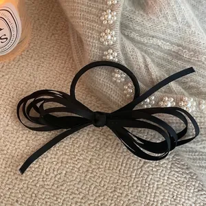 Elegant multi-layered black ribbon bow hair scrunchie with a French vintage aesthetic
