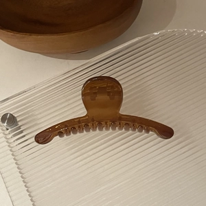 Détail d'une pince à cheveux ambre translucide avec finition lisse et ressort durable