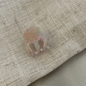 Detailed macro view of a mini acetate hair claw clip with pink and blue marble patterns