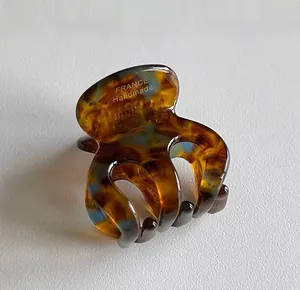 Detailed view of handmade acetate hair claw clip with tortoise and blue patterns