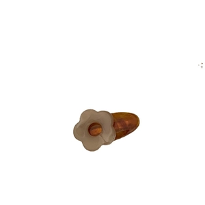 Minimalist flower hair clip with matte beige petals and amber resin base on white background