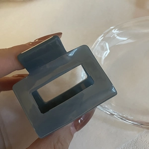 Pince à cheveux carrée en acétate style français en bleu gelée élégant tenue à la main