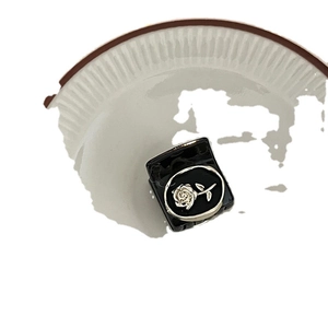 Retro black square hair claw clip with silver rose carving on white ceramic plate