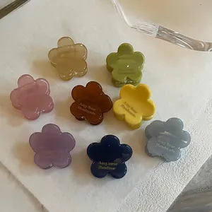 Vue à plat de petites pinces à cheveux fleur en 8 couleurs avec finition en résine
