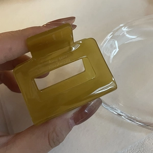 Détail d'une pince à cheveux carrée vert olive en acétate avec texte Amy bear fait main