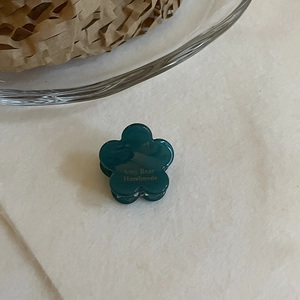 Détail de la mini pince à cheveux fleur vert foncé avec logo Any Bear Handmade