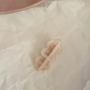 Detailed macro view of pink marble resin hair clip with geometric serrated edge texture