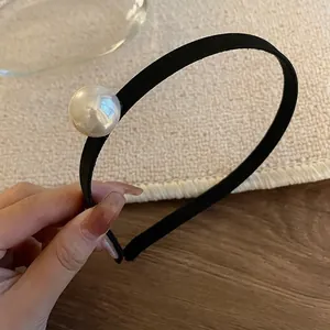 Elegant thin black headband with a large single white pearl accent for high crown hair styling