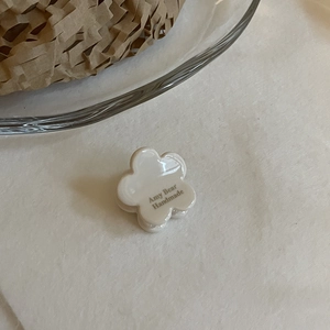 Gros plan détaillé de la mini pince à cheveux fleur crème avec texte Amy Bear fait main