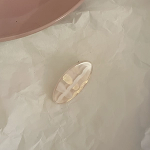 Detailed macro view of cream resin hair clip with elegant golden marble texture finish