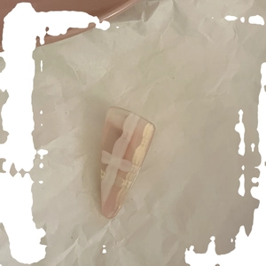 Pink resin hair clip with marble texture and gold accents on textured background