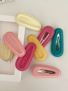 Detail of matte finish candy colored BB hair clips featuring the embossed LOVELY text