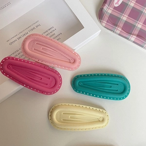 Detail of four matte pastel hair clips with LOVELY engraving and wavy edges in a set