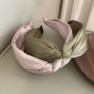 Elegant twisted satin headbands in soft pink and olive green for a minimalist style
