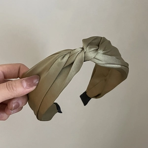 Elegant olive green satin knotted headband with vintage French style held by hand