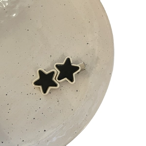 Y2K star hair clip with black and white star design on a white ceramic plate
