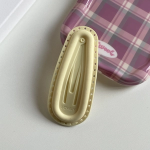 Close-up of cream silicone hair clip with lovely lettering and hollow dots detail