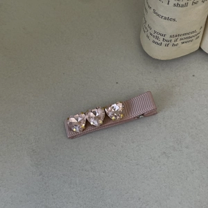 Close-up of pink heart crystals and ribbed ribbon wrapping on the sweet Lolita hair clip