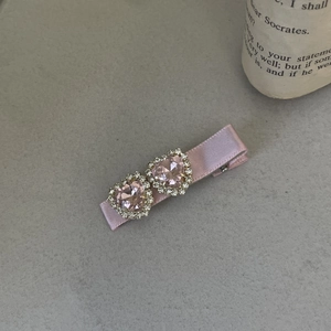 Detailed view of pink ribbon hair clip with double crystal hearts and glittering rhinestones