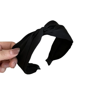 Elegant black twisted knot headband in minimalist French style with textured fabric