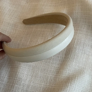 Detail view of the soft beige faux leather sponge headband with non-slip brown lining