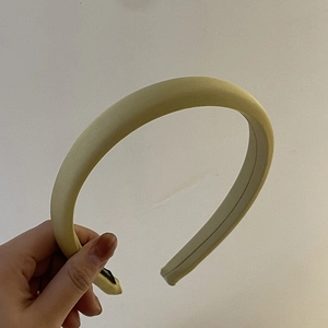 Detail of pale yellow satin padded headband with a high-top thick sponge design