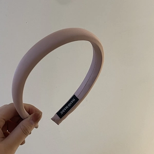 Detail of pink sponge headband featuring a handmade label on the matte inner lining