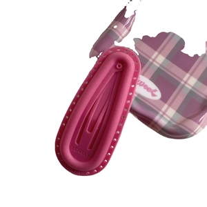 Pink matte silicone puff hair clip with LOVELY lettering on a purple plaid background