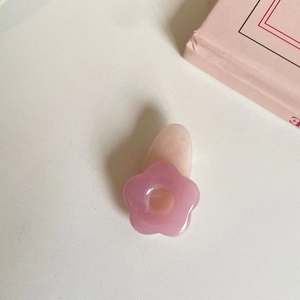 Rosa Blumenhaarklammer aus Harz auf weißem Schreibtisch für süßes, minimalistisches Styling