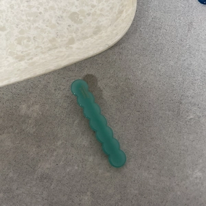 Fermaglio per capelli ondulato stile francese in resina verde su fondo di pietra
