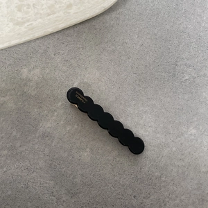Dettaglio molletta per capelli nera ondulata con scritta dorata France Handmade di lusso