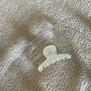 Mini cream yellow translucent claw clip for hair styling on an elegant display tray