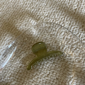 Mini olive green translucent hair claw clip for women displayed in a glass bowl