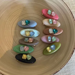 Detailed set of acetate oval hair clips featuring colorful heart and rectangle gemstones