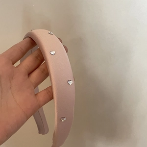 Dettaglio del cerchietto in raso rosa con strass scintillanti a forma di cuore