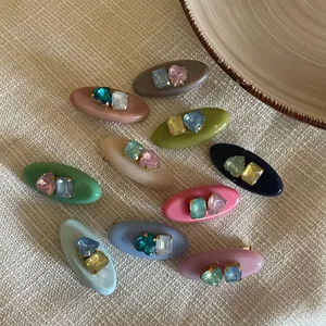 Detailed close-up of candy-colored acetate hair clips with heart-shaped rhinestones