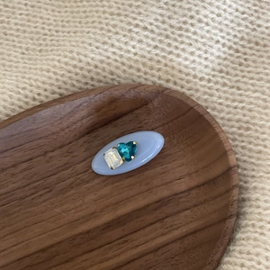 Detail of light blue acetate hair clip with blue heart gem on rustic wooden tray