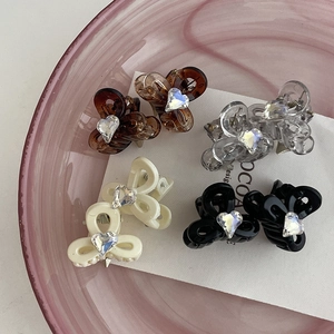 Mini butterfly hair claws with heart rhinestones in amber, white, and black colors