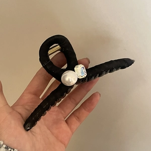 Large black fabric hair claw clip featuring an oversized pearl and rectangular crystal