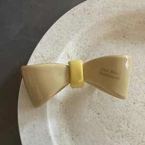 Detaillierte Nahaufnahme einer französischen Haarspange aus Acetat auf einem Keramiktablett