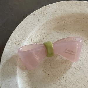 Französische rosa Acetat-Schleifen-Haarklammer mit grünem Akzent und Logo