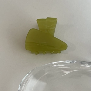 Détail macro de la pince à cheveux en acétate vert olive avec l'inscription Barrette La France