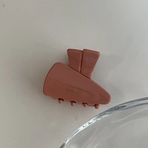 Détail d'une pince à cheveux en acétate rose avec lettrage doré Baguette élégant