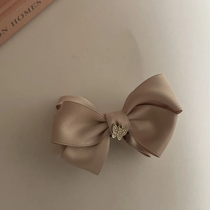 Pince à cheveux élégante en satin champagne avec un nœud et un papillon en strass brillant