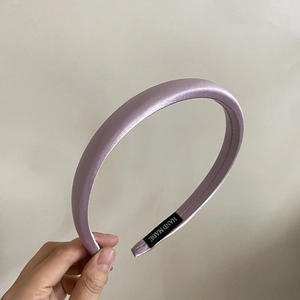 Détail du serre-tête en satin lilas avec étiquette intérieure Hand Made visible