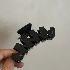 Macro di una pinza per capelli nera a zigzag con finitura lucida ed elegante