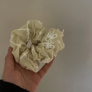 Pale green scrunchie with white lace embroidery and soft pleated fabric hair tie
