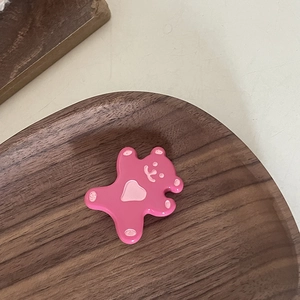 Barrette à cheveux ours rose mignon en résine lisse sur un plateau en bois