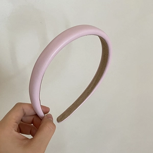 Detail view of pink thickened faux leather headband with a brown non-slip lining