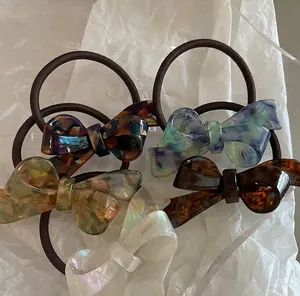 Five pack of amber acetate bow hair ties in assorted tortoiseshell and marble patterns
